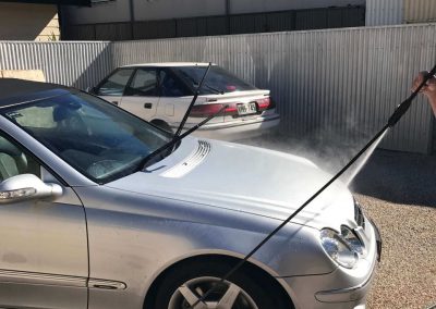 The car is rinsed in sections as part of the mobile detailing process